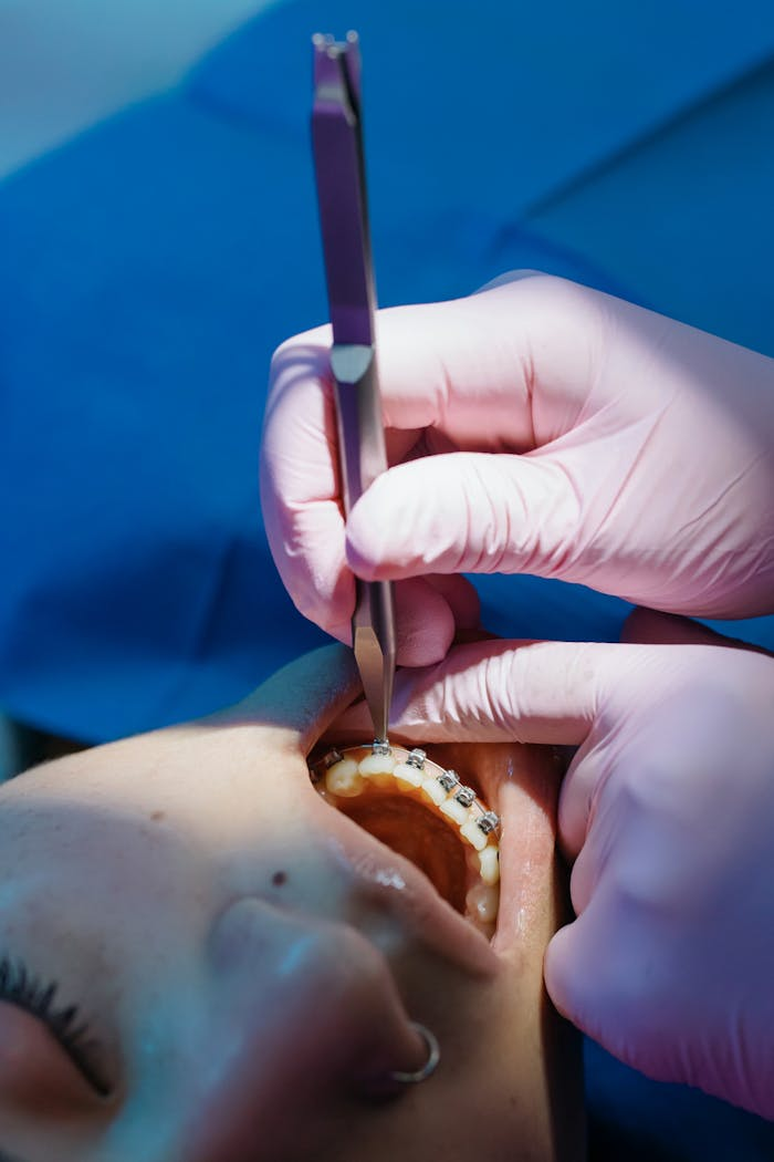 Dentist examines orthodontic braces during dental care procedure in clinic.